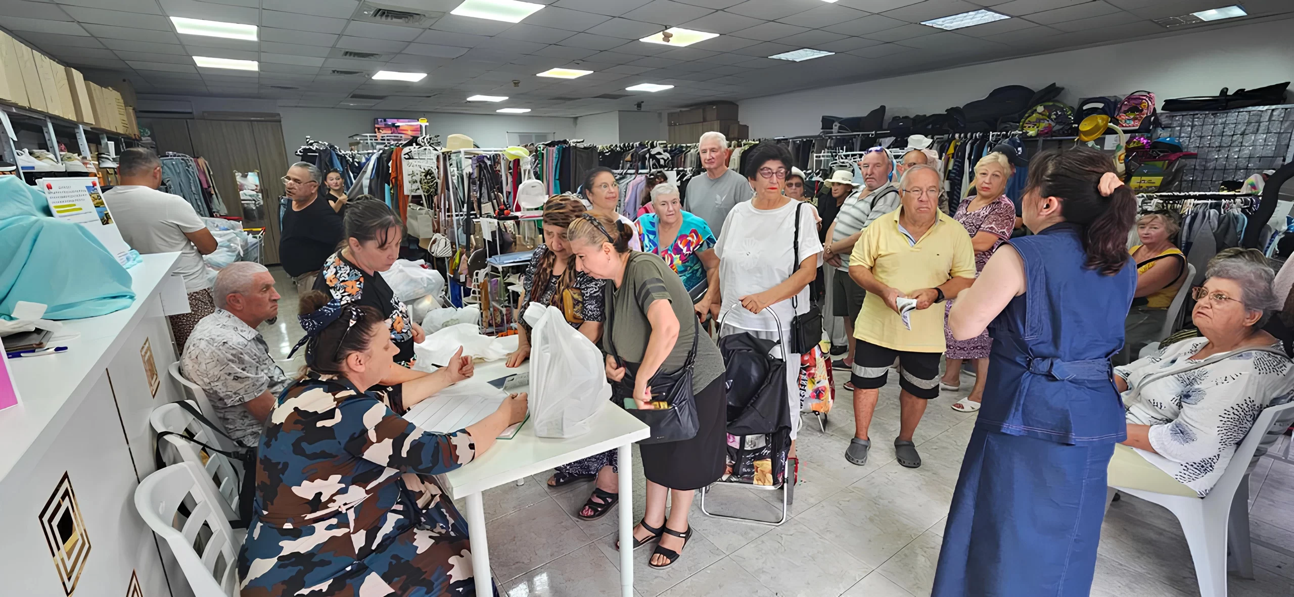 Seniors and residents waiting in line to register with staff at the Help distribution center.