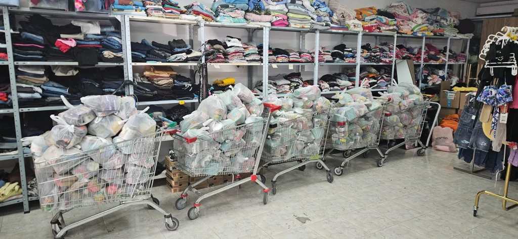 Row of shopping carts overflowing with packed white bags ready for families at the Help distribution center.