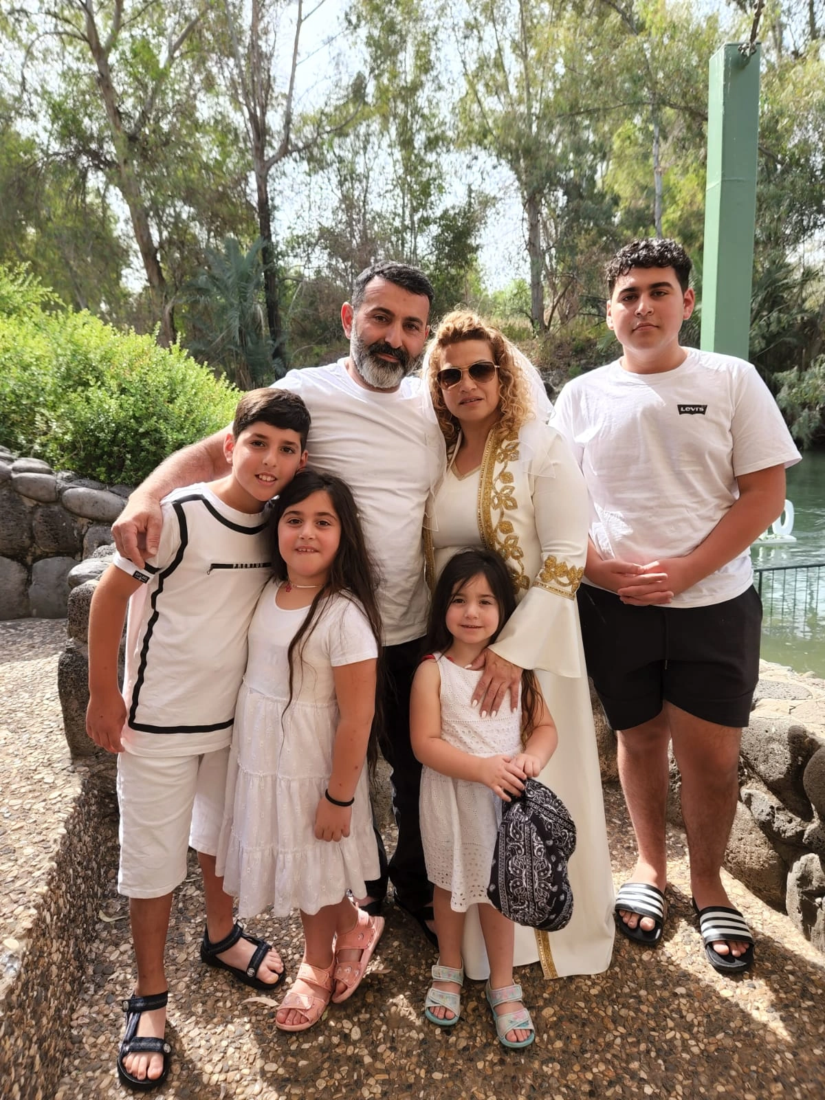 Two men standing together on a wooden dock by the river at the recovery home.
