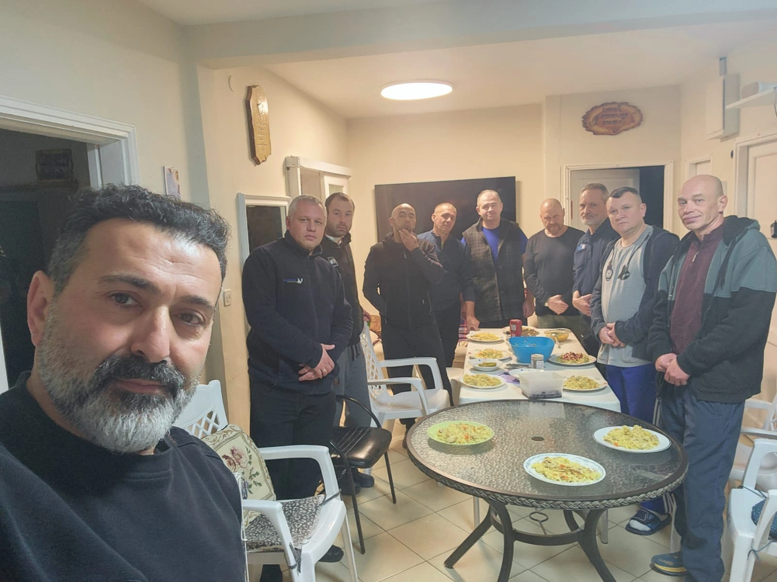 Two men standing together on a wooden dock near the tall reeds at the recovery home.